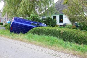 Bestelbus belandt ondersteboven in tuin