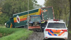 Vrachtwagen glijdt van de weg door klei