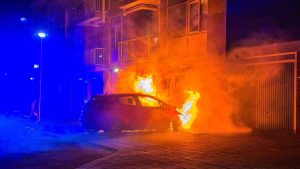 Auto brandt uit tegen gevel van flatgebouw
