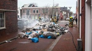 Rijdende vuilniswagen vliegt in brand in Den Helder, huisvuil op staat gegooid