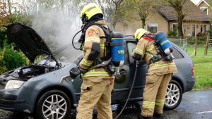 Rijdende personenauto vat vlam