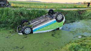 Auto op de kop en in de sloot, nat pak voor inzittenden