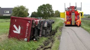 Vuilniswagen kantelt in sloot