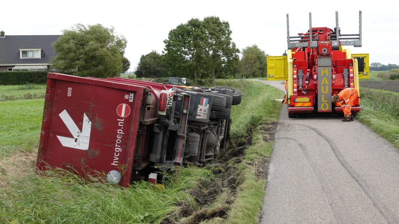 Vuilniswagen kantelt in sloot