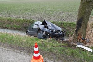 Auto tegen boom en te water