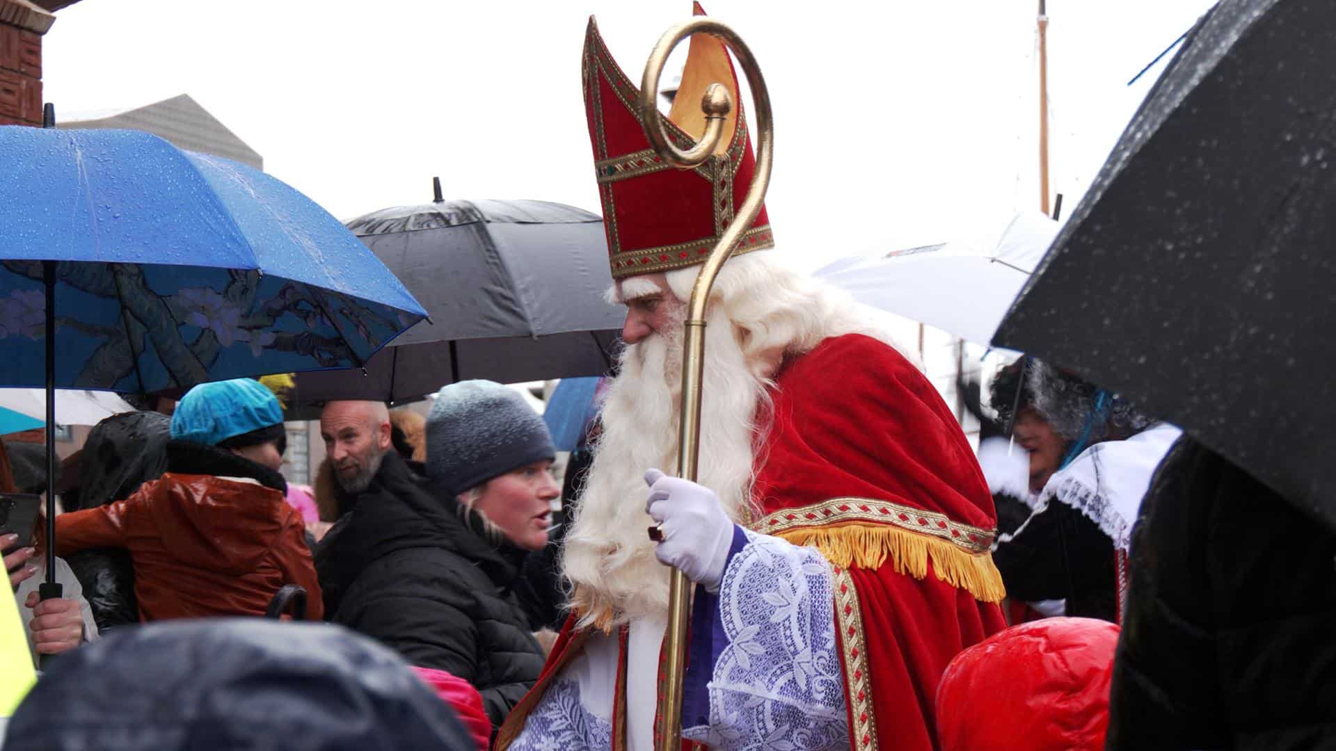 Video: Kinderen bikkelen in de regen om Sinterklaas te kunnen zien