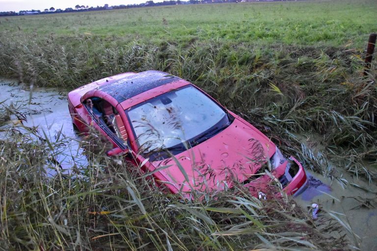 Auto belandt in water bij Westfriesedijk
