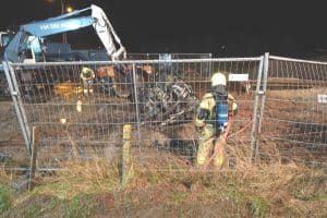 Auto over de kop en in brand