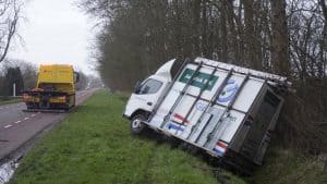 Glaszetter met bedrijfsauto in diepe greppel