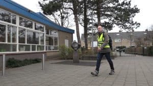 Leerkracht wandelt door de Noordkop, van school naar school